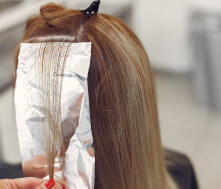 Licensed cosmetologist coloring hair.